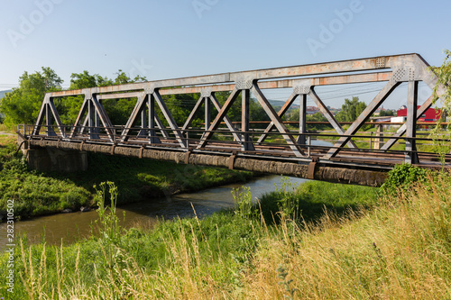 ODORHEIU SECUIESC, ROMANIA - July 2, 2019: Diagonal view on an old bridge with steel supports. Concept / metaphor for opportunity, connection, communication, teamwork, business, transportation, travel photo