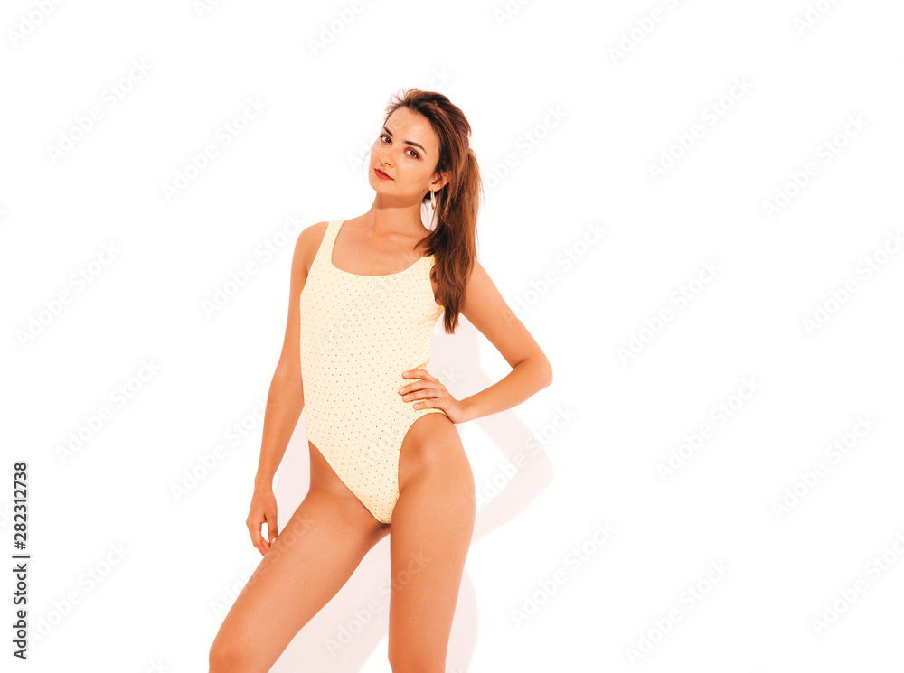 Portrait of young beautiful sexy smiling hipster woman in yellow swimwear bathing suit.Trendy girl. Positive female going crazy.Funny model isolated on white