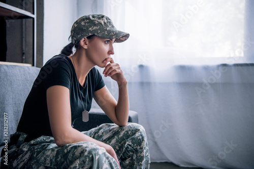 Obraz na płótnie Depressed lonely woman in military uniform at home