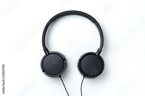 Black headphones isolated on white background. Flat lay top view copy space. Music concept. Minimal style