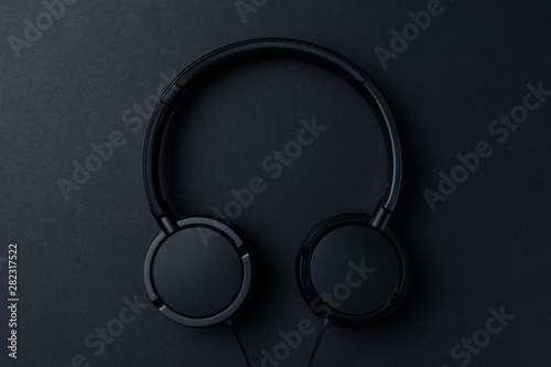 Headphone. Music concept. Flat lay: headphones on black background. Top view. Trendy colorful photo. Black headphones on yellow background. Music concept. Minimal style
