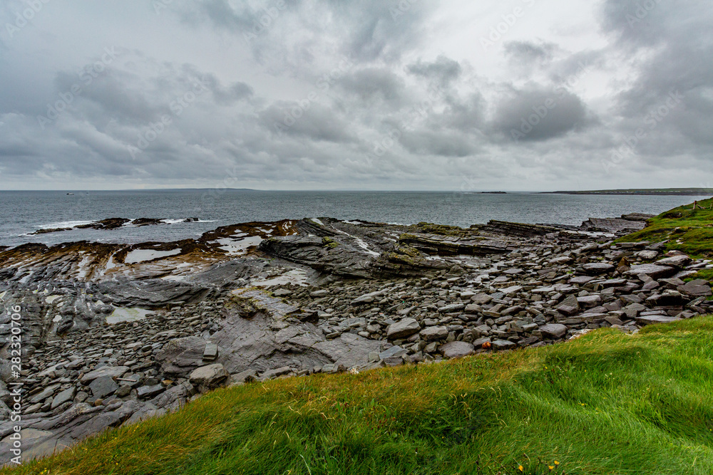 Beautiful limestone view on the coast in the coastal walk route from Doolin to the Cliffs of Moher, geosites and geopark, Wild Atlantic Way, rainy day in county Clare in Ireland