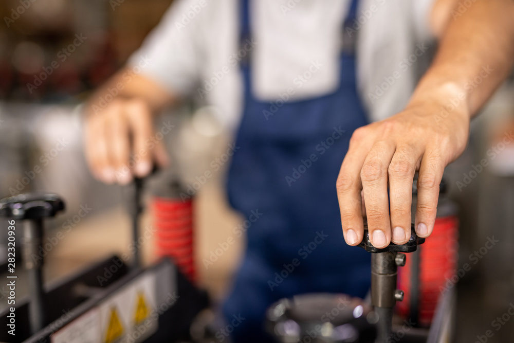 Hand of technician or engineer turning one of handles of industrial equipment Hand of technician or engineer turning one of handles of industrial equipment