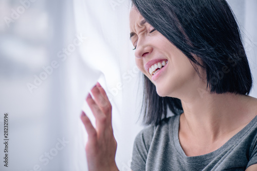 selective focus of depressed crying brunette woman at home