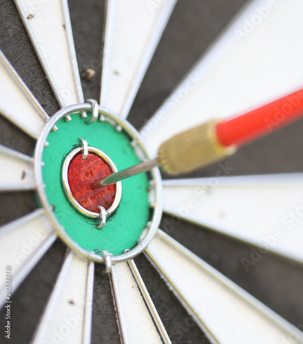 Close-up image with a dart in the bullseye of a practice target