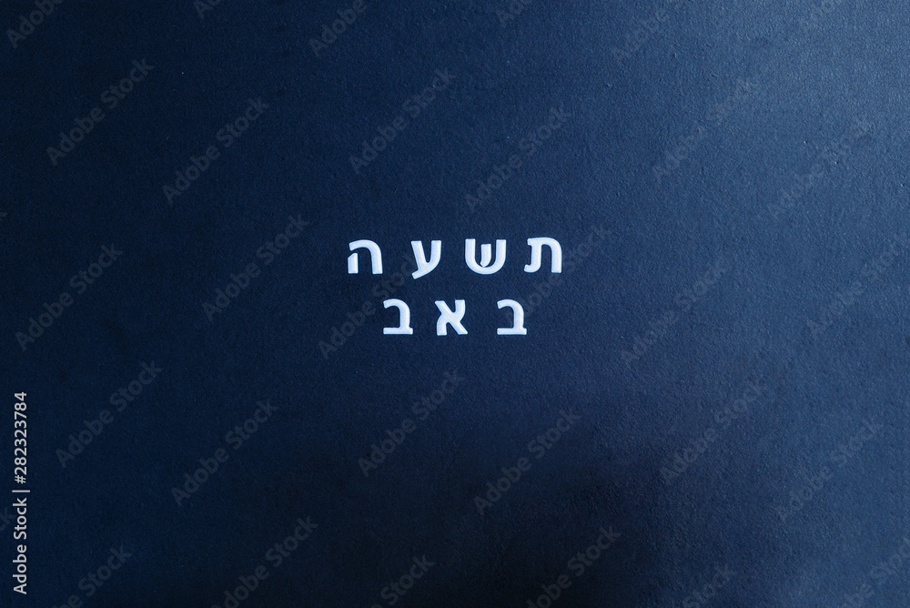 School black chalkboard with text Tisha B'Av written in hebrew. Tisha B'Av day in Judaism, on which a number of disasters in Jewish history occurred. School black chalkboard with text Tisha B'Av written in hebrew. Tisha B'Av day in Judaism, on which a number of disasters in Jewish history occurred.