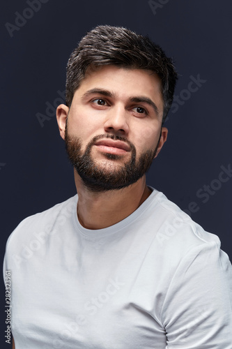 good looking arab in casual clothes guy looking up, rest, leisure time concept. isolated black background, studio shot