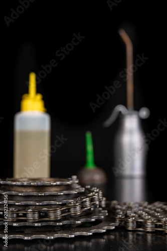 Oiling the bicycle chain with an oil can on the workshop table. Servicing of bicycle parts.