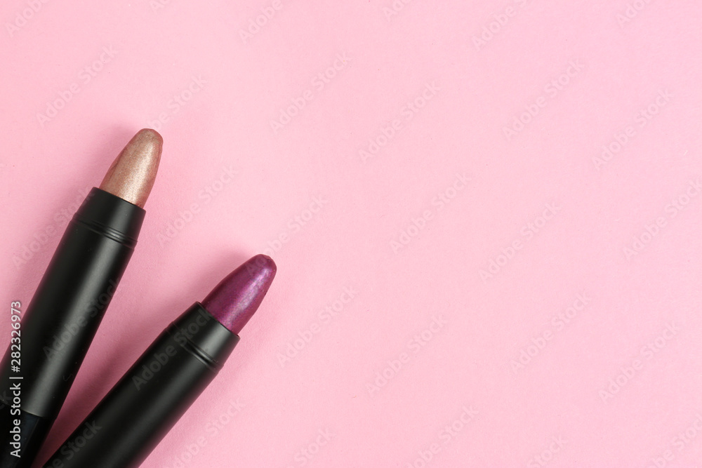 Bright lipsticks in black tubes on pink background, flat lay. Space for text Bright lipsticks in black tubes on pink background, flat lay. Space for text