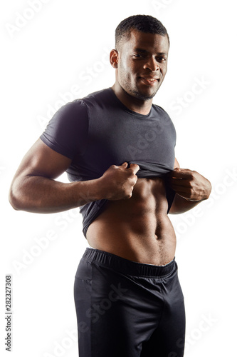 Muscular young man showing ideal abs.close up portrait. vertical shot. lifestyle, result of workout. hobby, interest, isolated white background