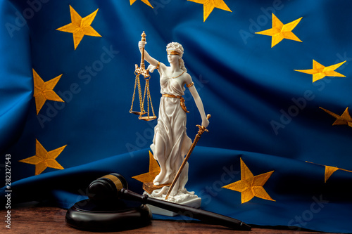 European union court of justice or ECJ, legal system in Europe and the legislature branch of government concept with a gavel, a statue of Themis the lady of justice and the EU flag photo