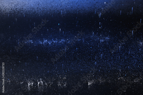 Water drops falling on color background. Rainy weather