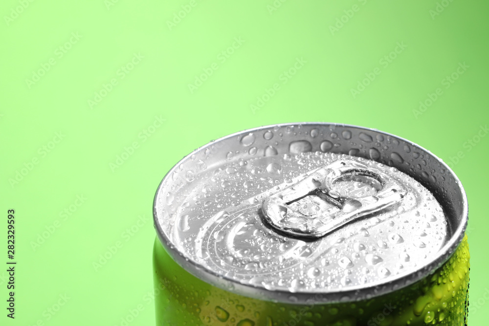 Aluminum can of beverage covered with water drops on green background, closeup. Space for text Aluminum can of beverage covered with water drops on green background, closeup. Space for text