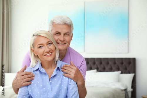 Portrait of happy senior couple at home. Space for text