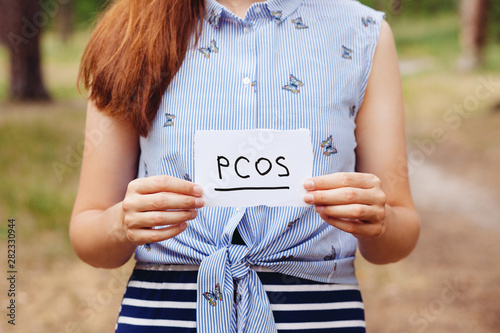 PCOS - Polycystic ovary syndrome, woman hormone sickness lettering on paper in womans hands photo