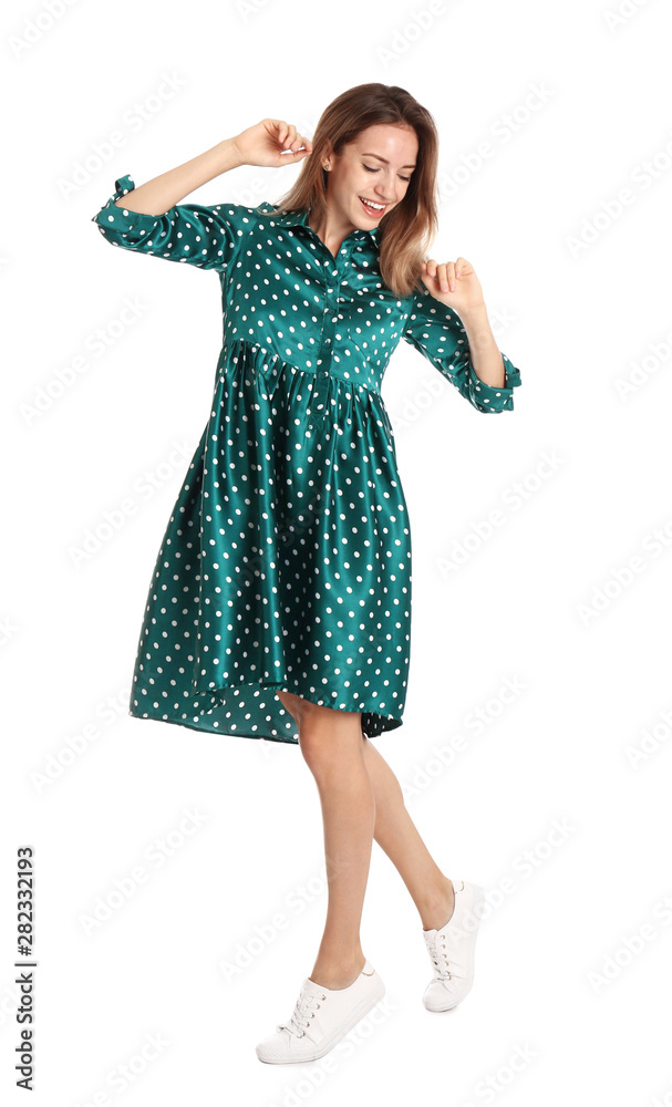 Fototapeta premium Beautiful young woman in green dress dancing on white background
