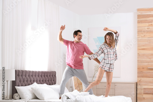 Beautiful young couple dancing in bedroom at home