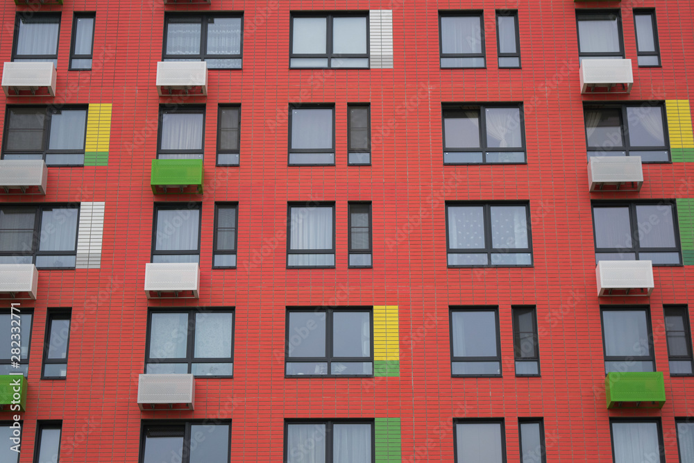 modern red facade of a multi-storey residential building, windows