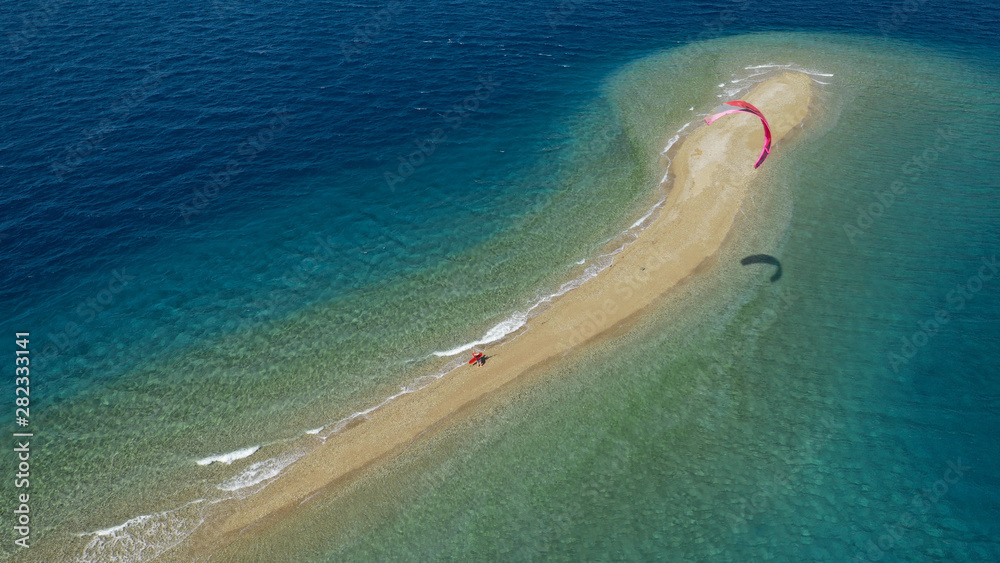 Aerial drone photo of kite surfer practising in tropical exotic sandbar part of island Atoll with turquoise and emerald open ocean sea