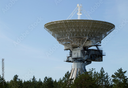 full size white radio telescope against the sky