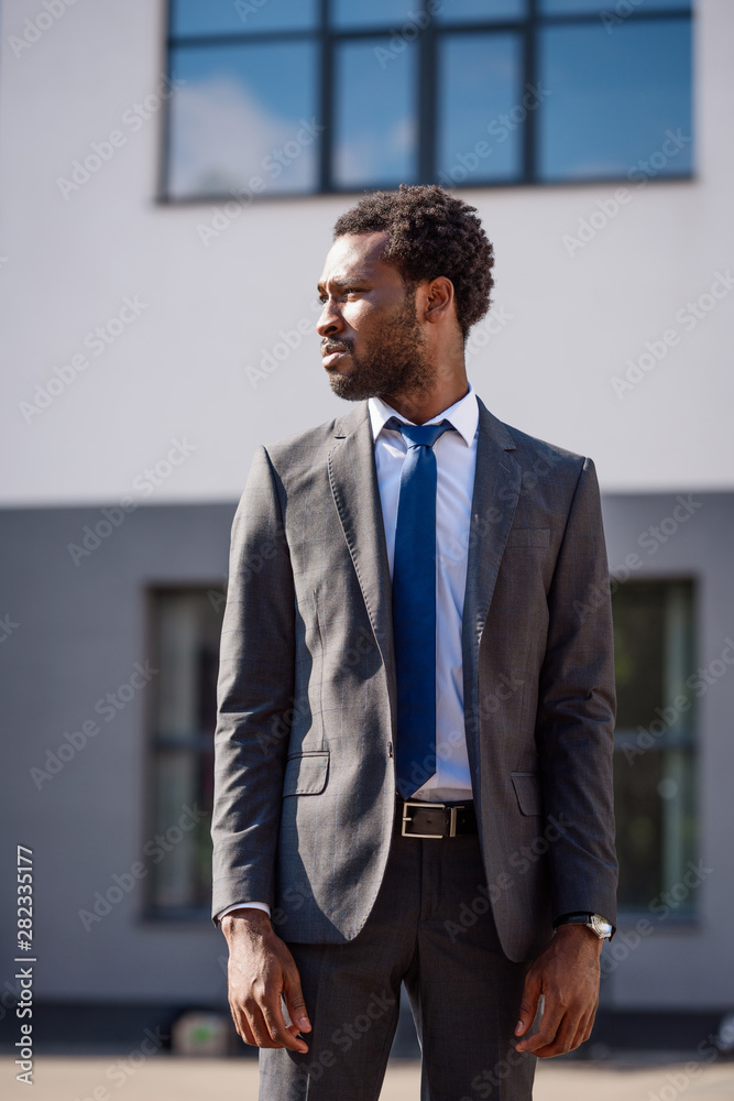 confident african american businessman in suit looking away on street confident african american businessman in suit looking away on street