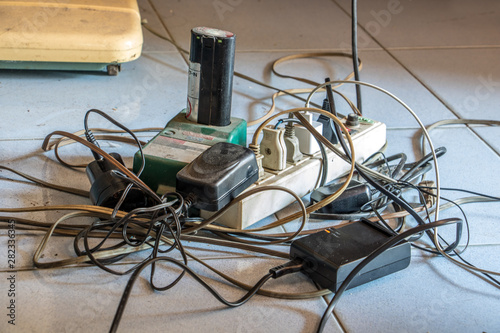 The extended socket with many adapters and chaotic cables on the floor.