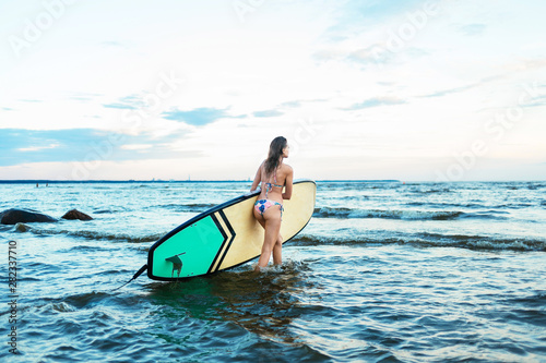 Canvas Print Beautiful fit surfing girl on surfboard on in the ocean