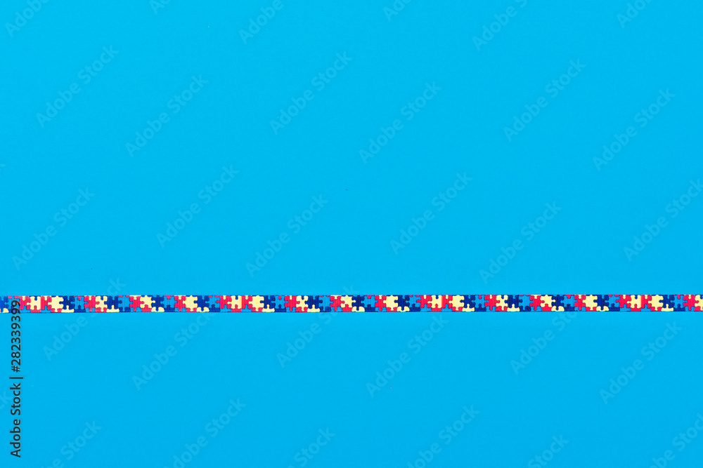 World Autism Awareness day, mental health care concept with ribbon puzzle pattern. On blue background. World Autism Awareness day, mental health care concept with ribbon puzzle pattern. On blue background.