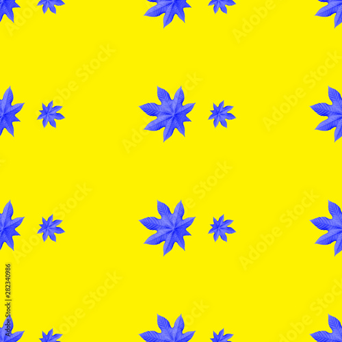 Seamless repeating pattern from blue ricinus communis on yellow background photo