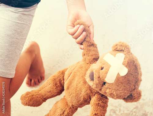 baby girl is holding a teddy bear in his hands