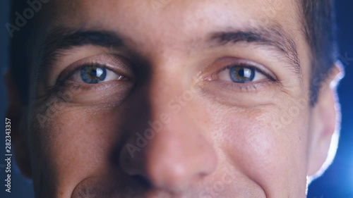 Close up eyes of young happy man looking into camera lens. Close-up of a male eyes.