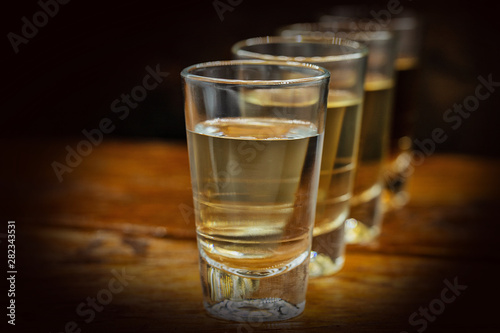 Several glasses of brazilian cachaça isolated on rustic wooden background, variations and types of brazil cachaça, typical drink from brazil.