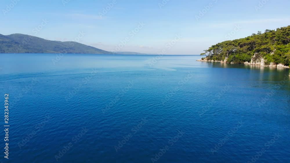 A scenic, steady aerial view of the Aegean Sea and the Gulf of Gokova coastline on a bright summer day. A scenic, steady aerial view of the Aegean Sea and the Gulf of Gokova coastline on a bright summer day.