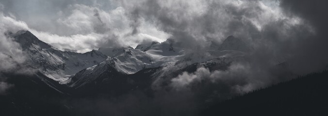 Poster Zwart Besneeuwde alpentop met stormwolken  © Tabor Chichakly