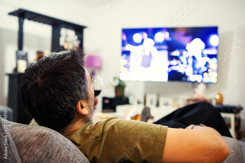 Relaxing Man Lying on Couch watching tv and Holding a Tv Controller 