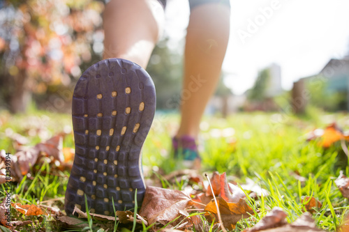 Woman wearing sport shoes doing exercise outdoors at autumn