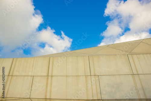 simple concrete building wall and blue sky white clouds background, city street art object 