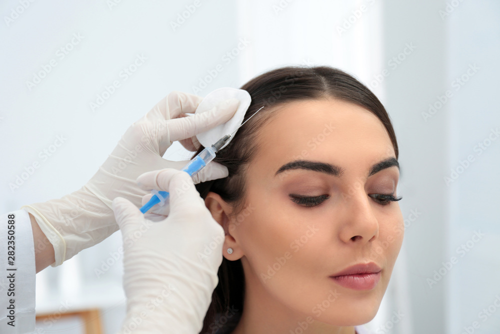Young woman with hair loss problem receiving injection in salon Young woman with hair loss problem receiving injection in salon