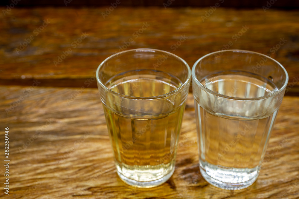 Several glasses of brazilian cachaça isolated on rustic wooden background, variations and types of brazil cachaça, typical drink from brazil. Several glasses of brazilian cachaça isolated on rustic wooden background, variations and types of brazil cachaça, typical drink from brazil.
