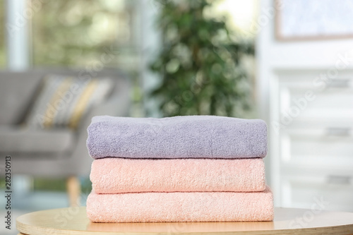 Stack of folded clean soft towels on table indoors