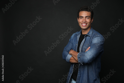 Handsome young African-American man on black background. Space for text