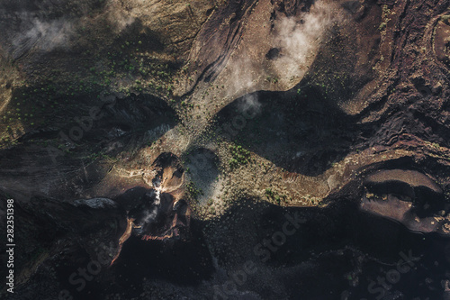 Aerial view of Batur volcano caldera in Bali. Volcanic black texture and crater rim, view from above, drone shot photo