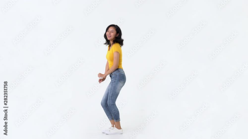 Happy young Asian woman in yellow t-shirt having fun smiling, dancing and looking at camera in studio white background Happy young Asian woman in yellow t-shirt having fun smiling, dancing and looking at camera in studio white background