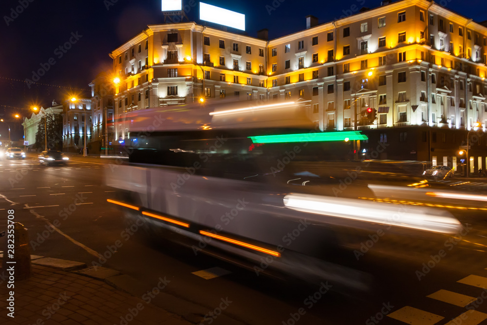 Motion blurred minibus on the avenue in the evening.