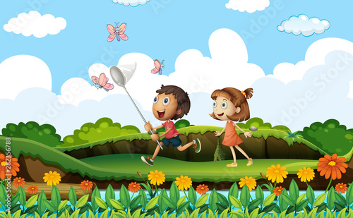Fototapeta Naklejka Na Ścianę i Meble -  Two kids catching butterflies in the park