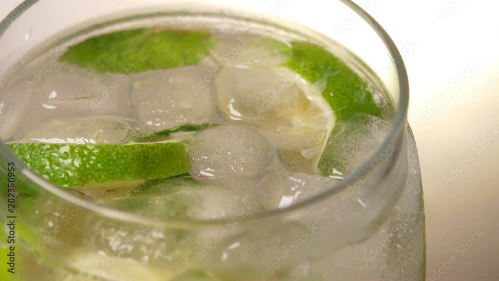 Top view Close-up Glass of cold fizzy refreshing drink with ice cubes. Soda with Ice in glass. Mineral bubbles. 360 rotation. 4K UHD video footage Top view Close-up Glass of cold fizzy refreshing drink with ice cubes. Soda with Ice in glass. Mineral bubbles. 360 rotation. 4K UHD video footage