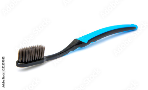 Blue toothbrush  black bristles charcoal Isolated on white background.