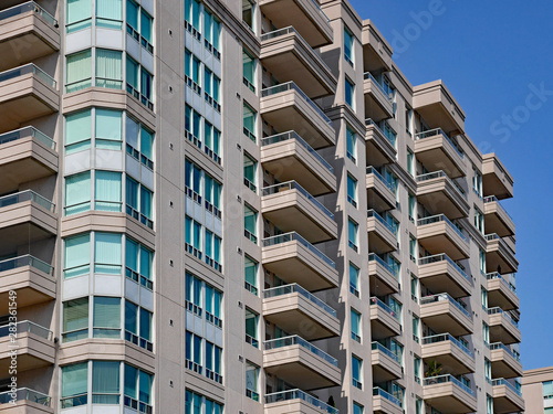 modern apartment building with balconies and green tinted windows