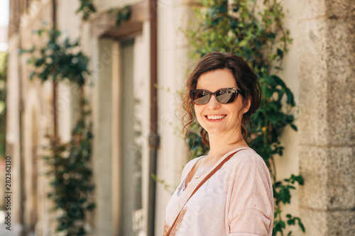 Outdoor portrait of beautiful woman wearing brown sunglasses © annanahabed