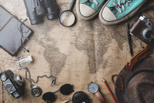 Travel Concept Background. Overhead View of Traveler's Accessories on Old Vintage Map photo